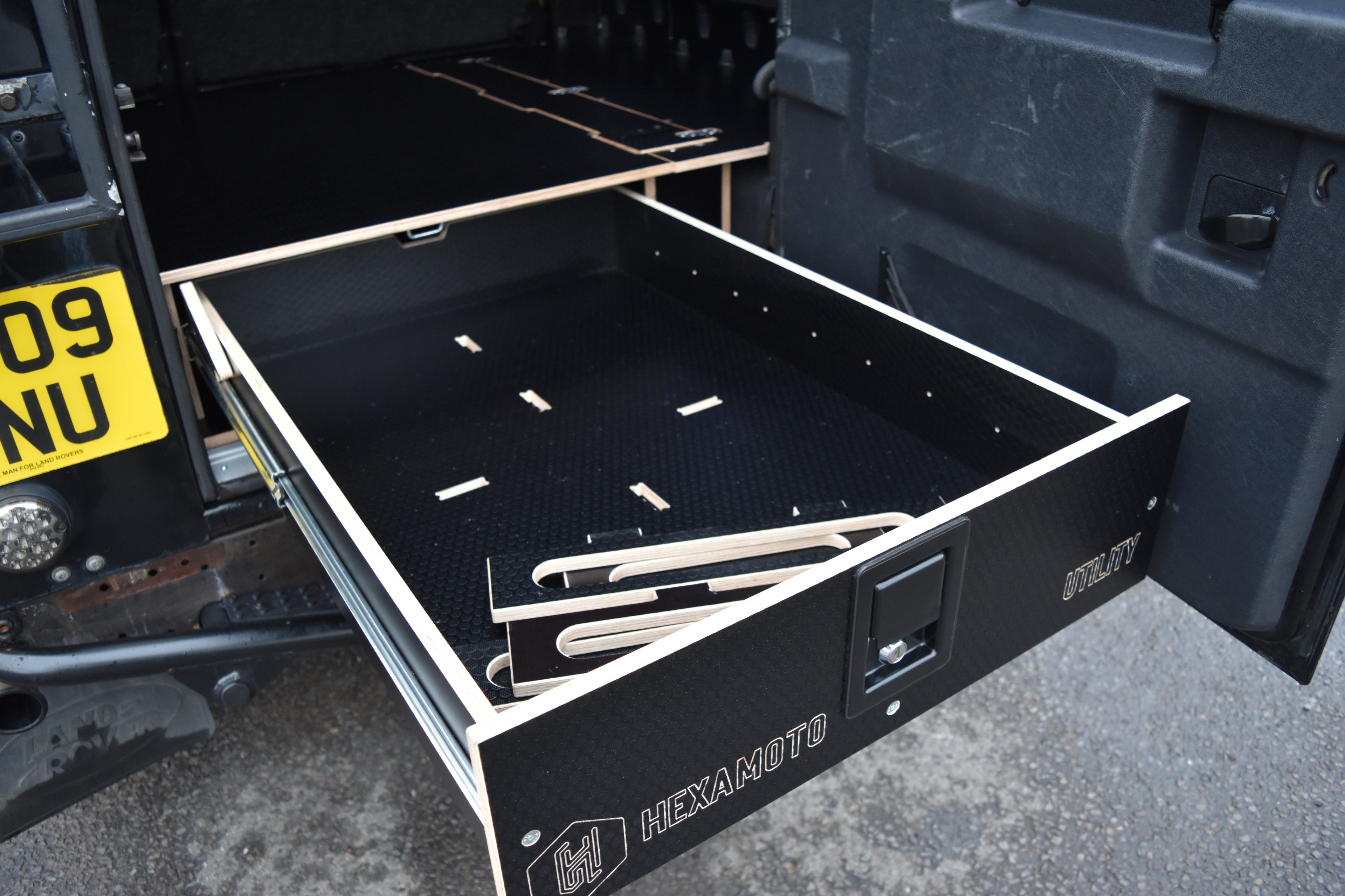 Open drawer with tools inside, attached to a vehicle, featuring HEXMOTO branding.