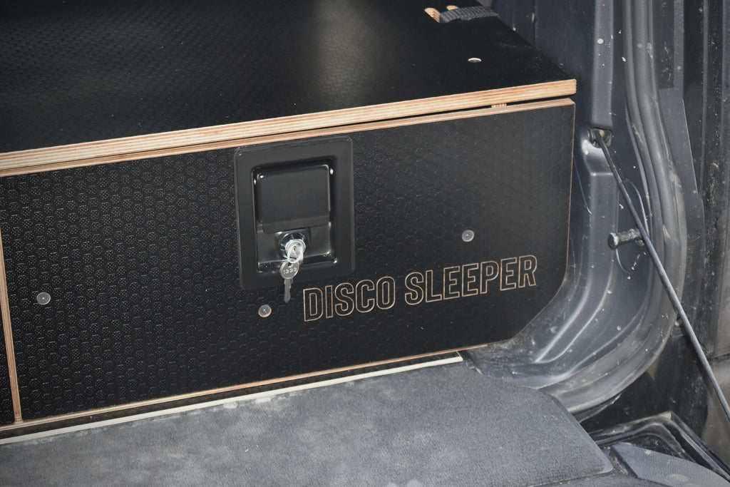 Black 'Disco Sleeper' storage system logo in the back of a car