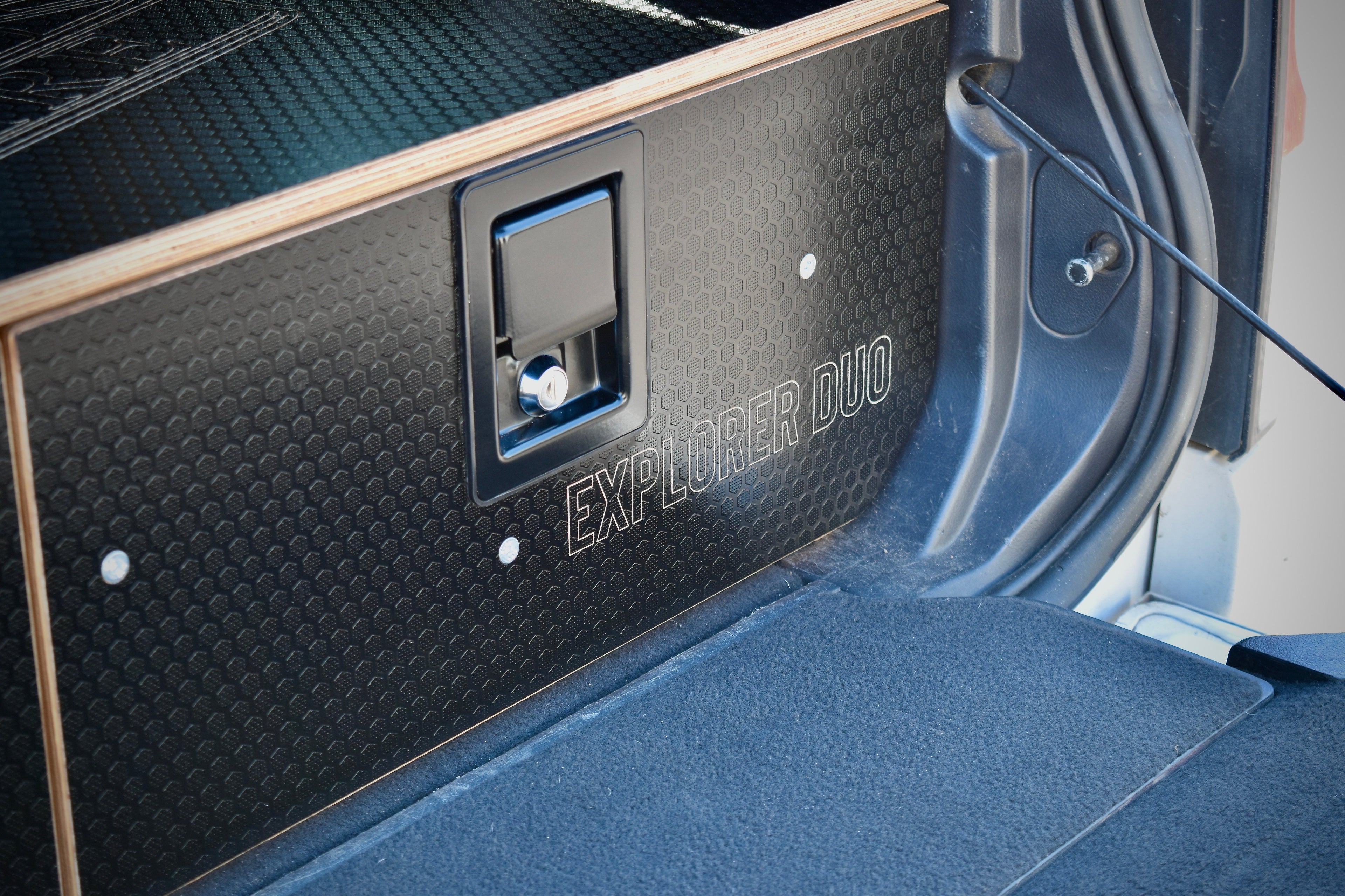 Car boot with 'Explorer Duo' engraving on a textured black panelled drawer