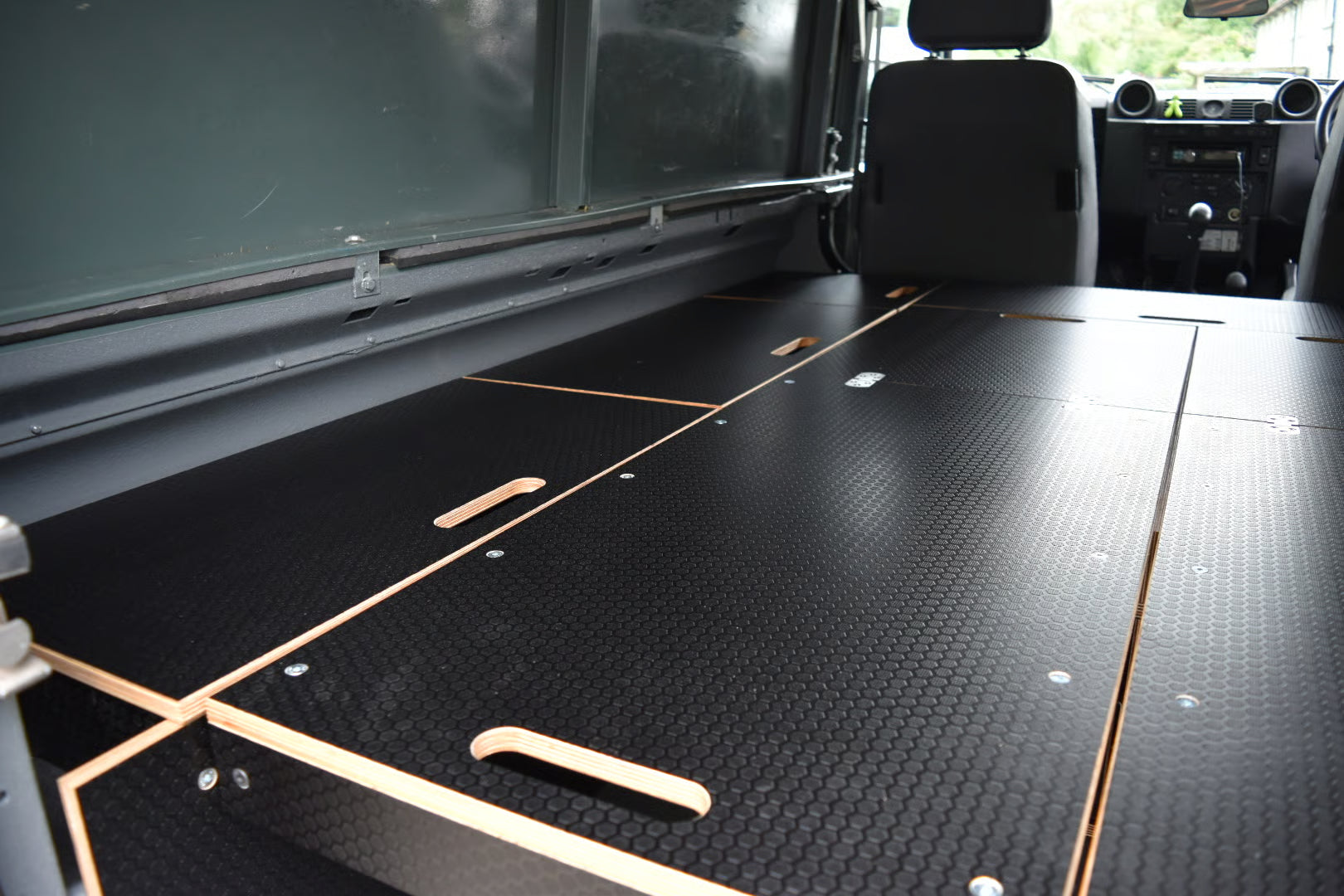 Black wooden bed platform as featured in the Hexamoto Defender Easy Sleeper 