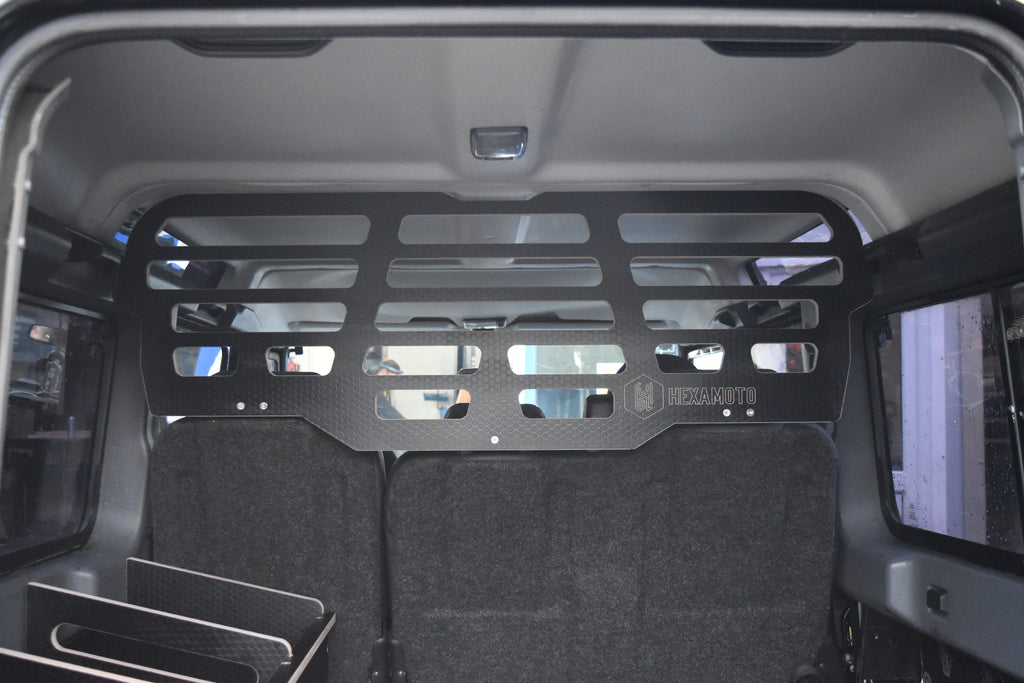 Back of a vehicle with a black wooden Hexamoto Dog Guard installed 