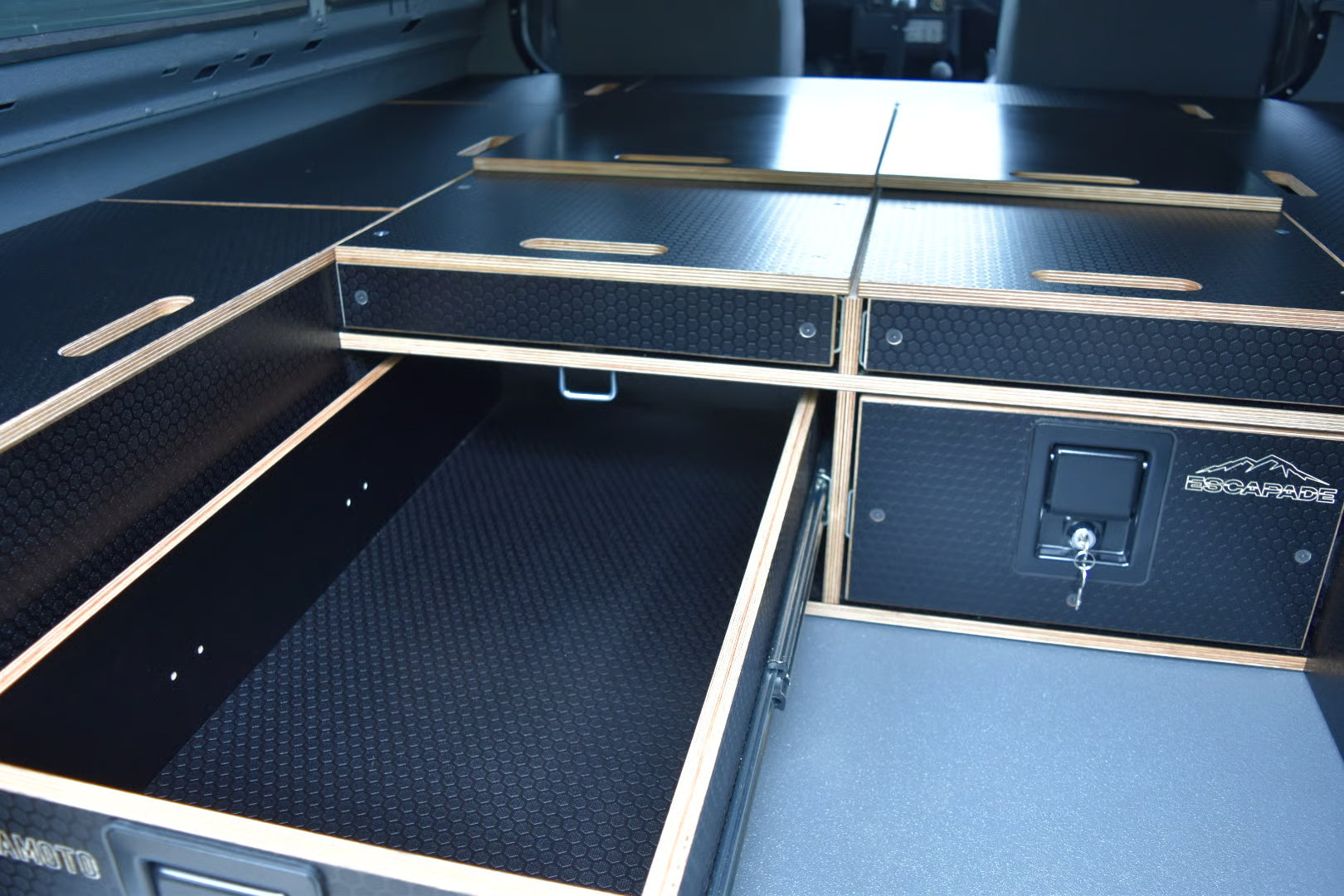 Open storage compartments with textured surfaces and a visible brand logo on a Defender interior