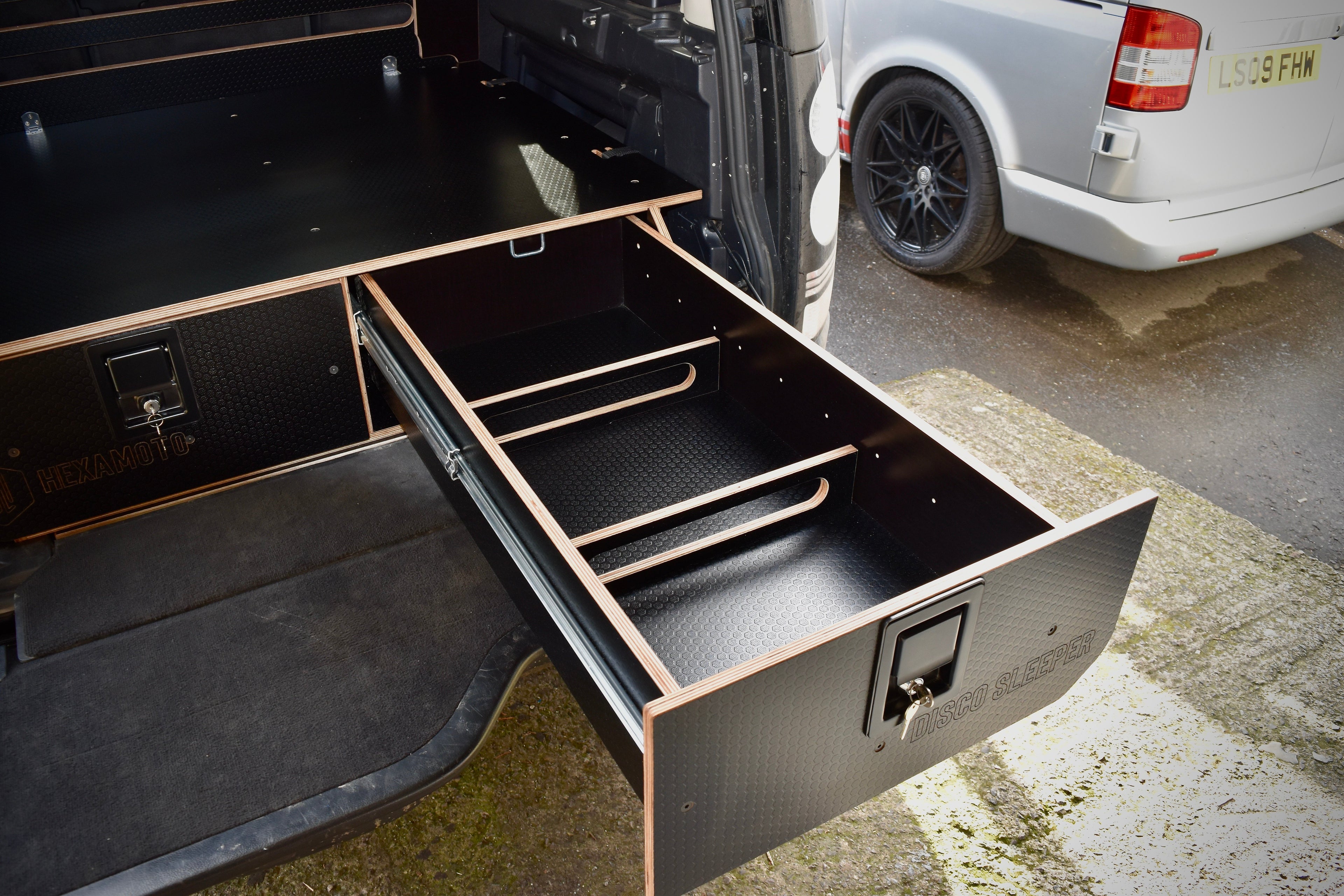 Open drawer in a vehicle with dividers, part of a larger storage system