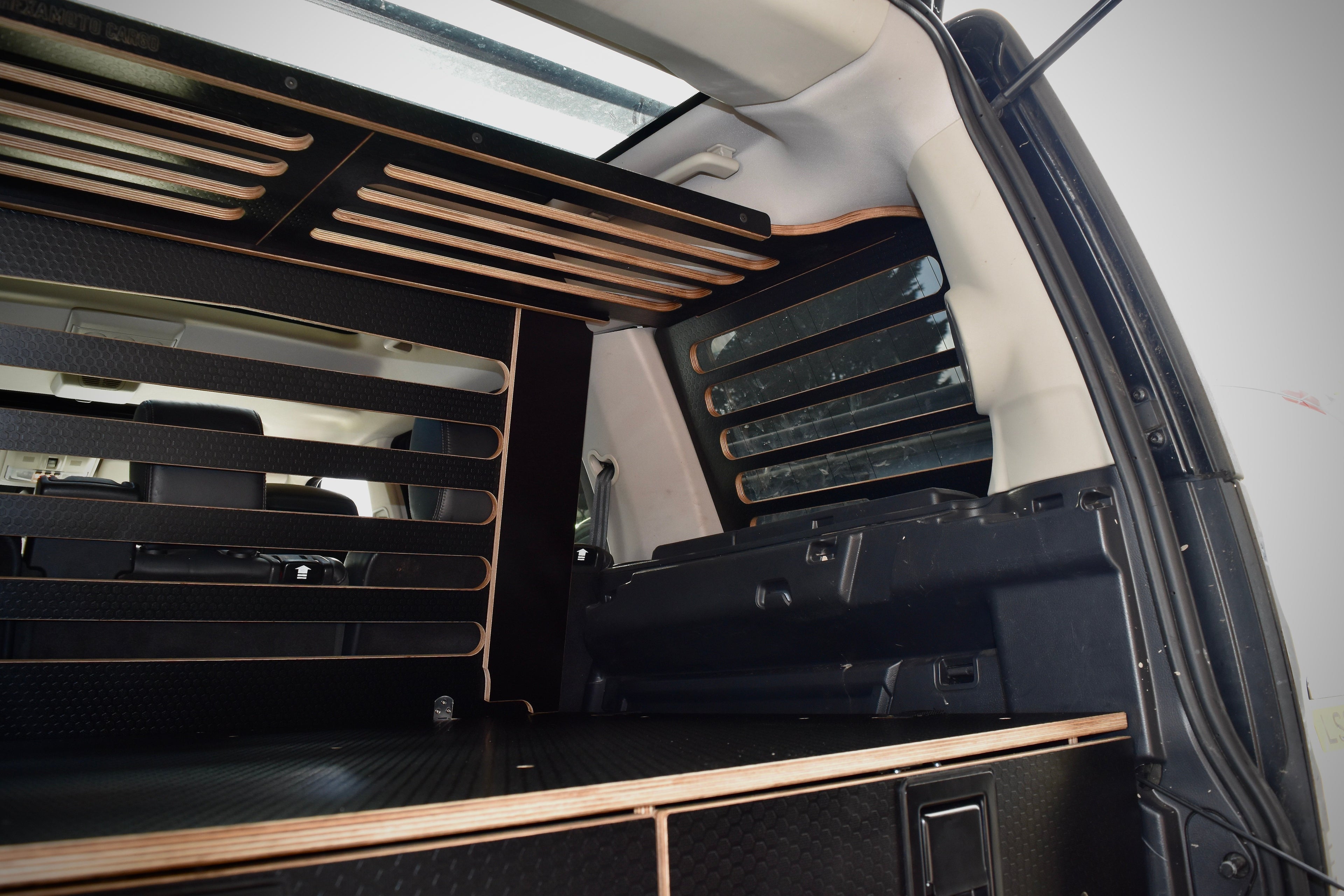 Car interior with overhead storage racks and drawer system 