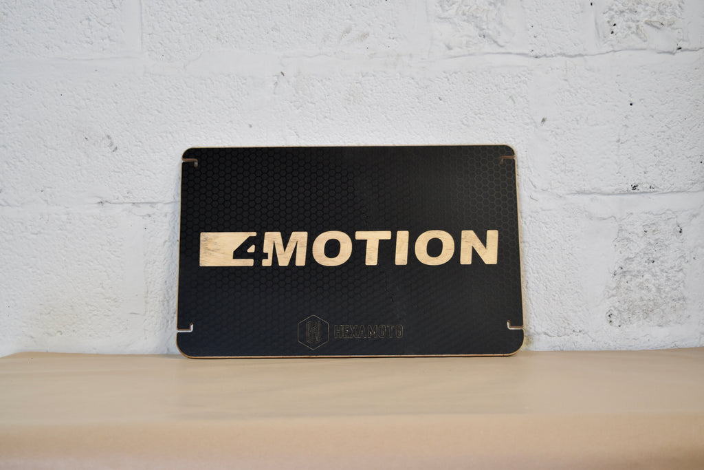 Black table with '4-MOTION' logo on a white brick wall background