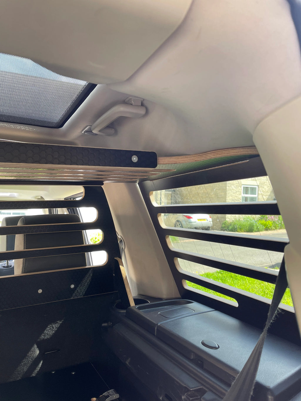 Car interior with window guards, overhead storage and dog guard installed