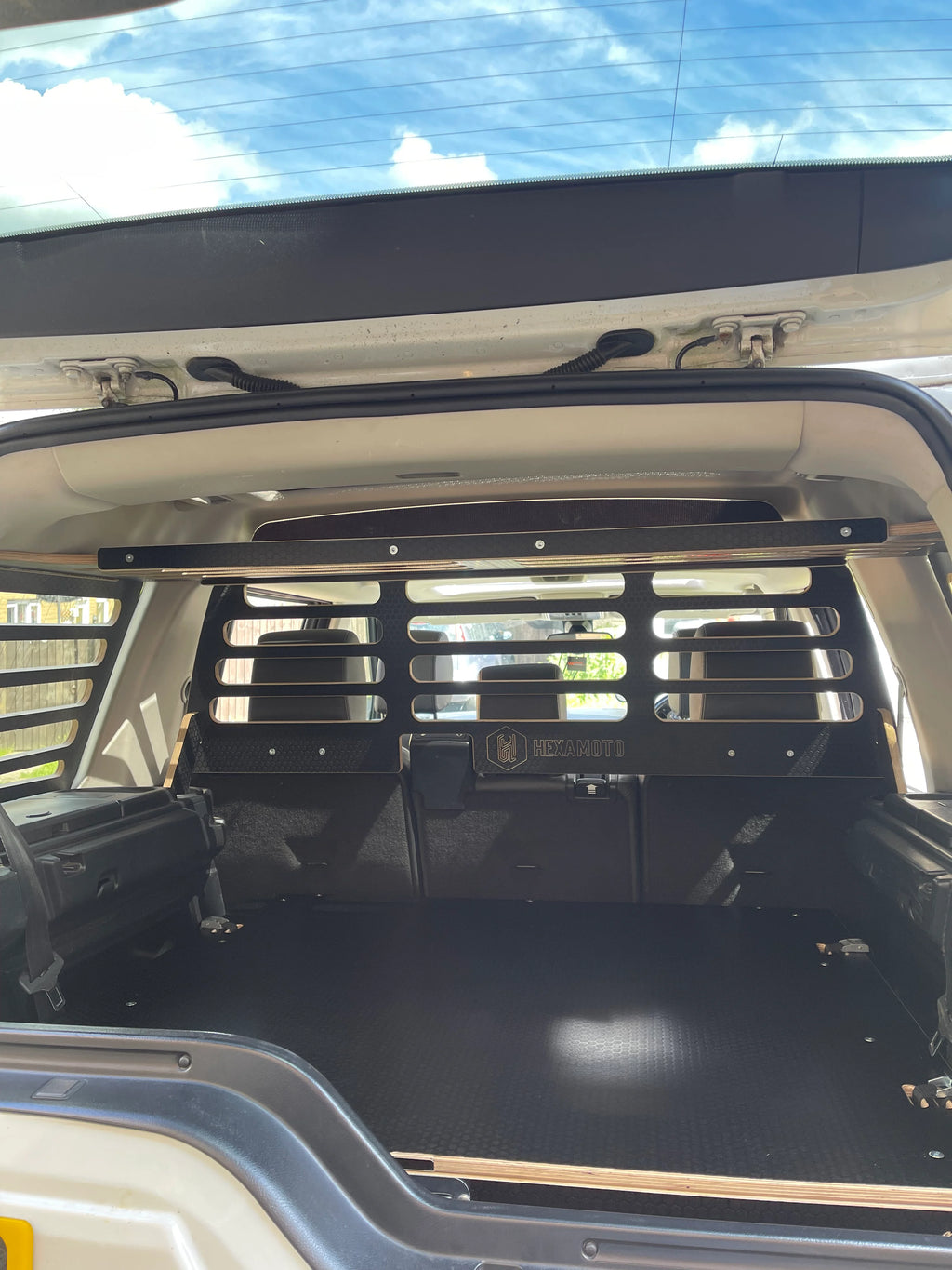 Open cargo area of a Land Rover Discovery 4 with Hexamoto Cargo Storage System, Dog Guard and Explorer Duo fitted