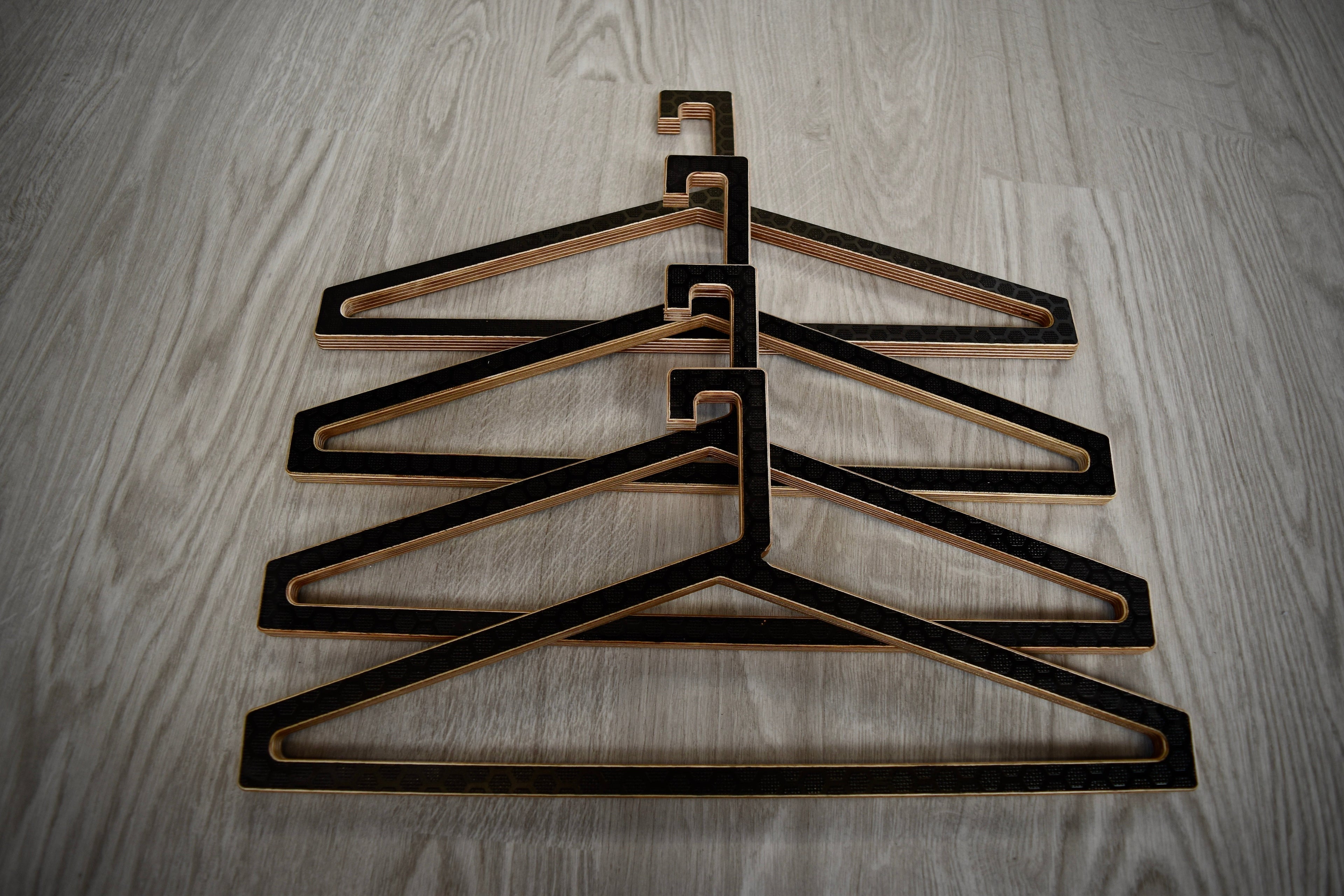 Set of black wooden hangers stacked on a wooden surface