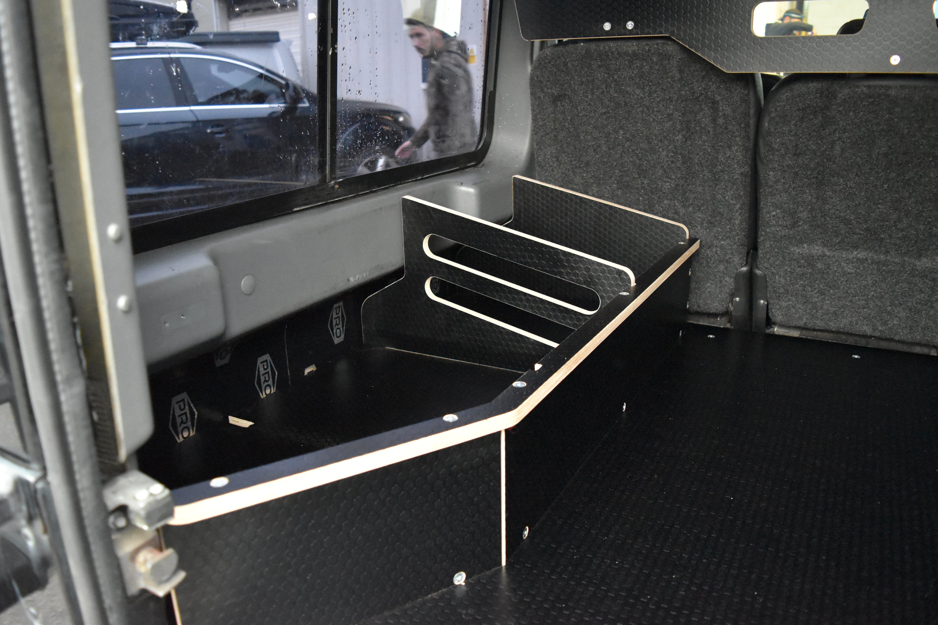 Back of a Defender 110 with Hexamoto Utility Storage basket fitted to the Hexamoto Utility System 