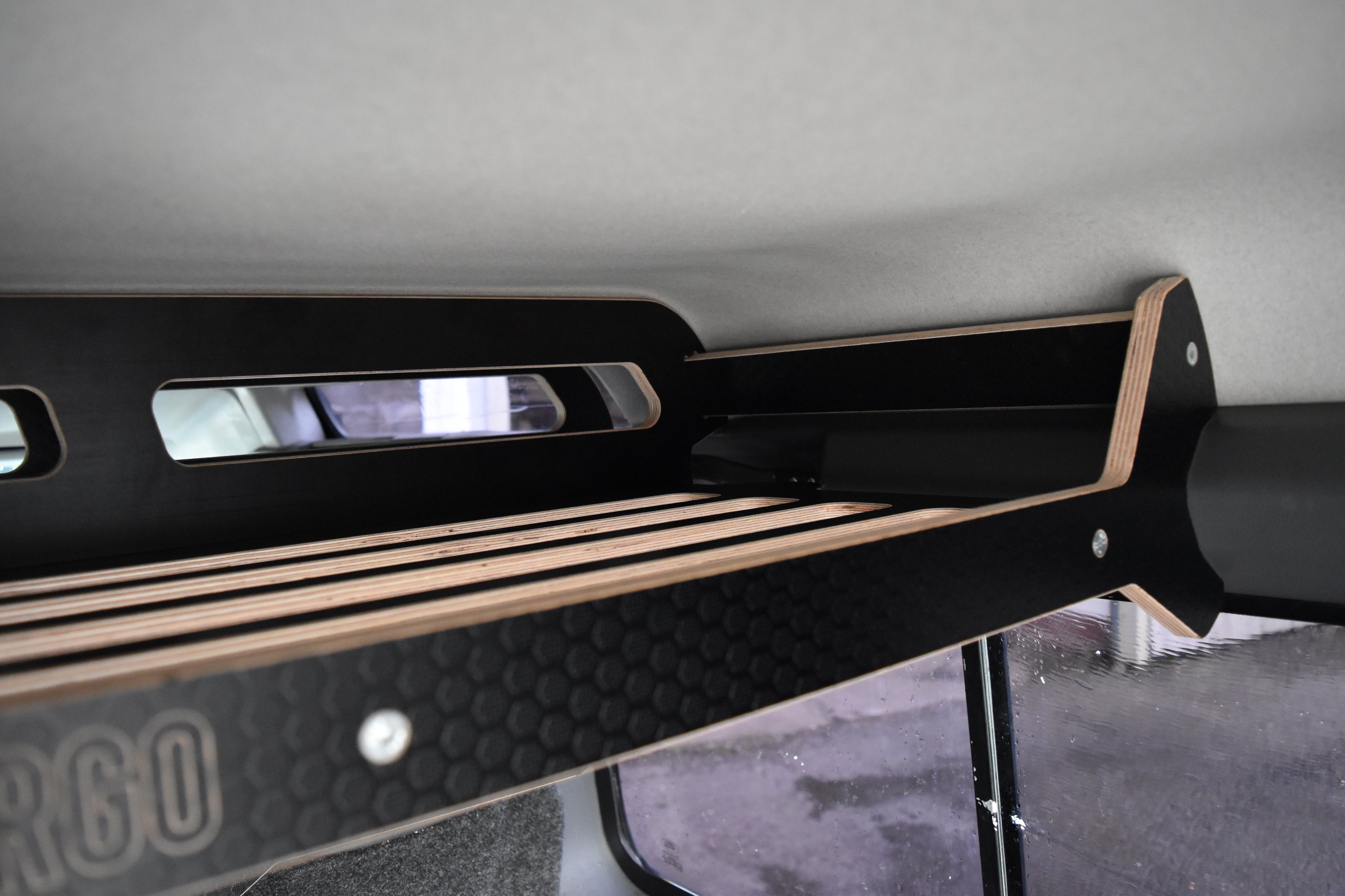 Black wooden storage system to fit overhead in a Defender 110 Stationwagon
