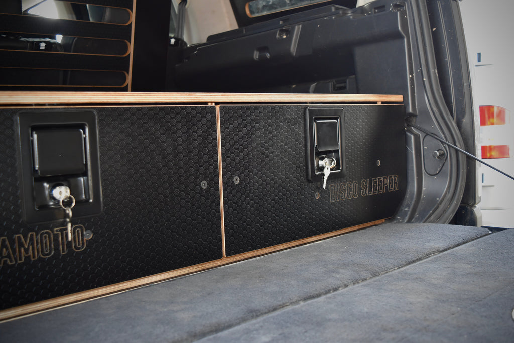 Back of a vehicle with a storage compartment labeled 'HEXAMOTO' and 'Disco Sleeper'.