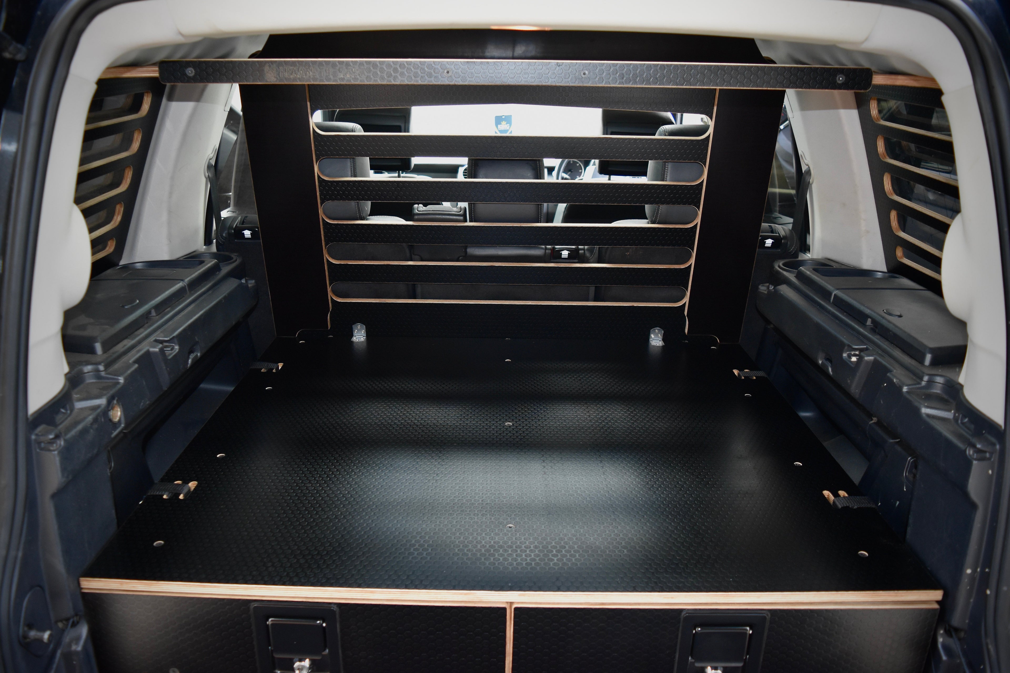 View from the rear of a Discovery vehicle with a storage system and up right cargo guard with overhead storage 