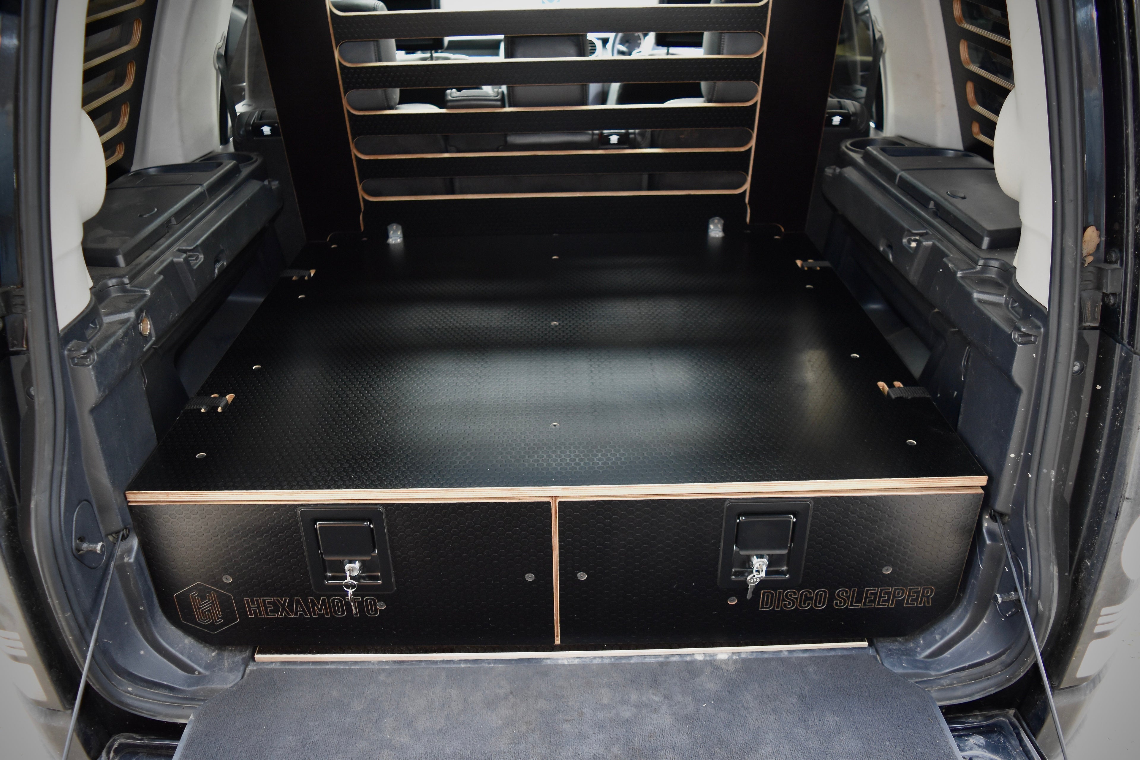 Vehicle boot showing custom storage system made by Hexamoto called 'Disco Sleeper'