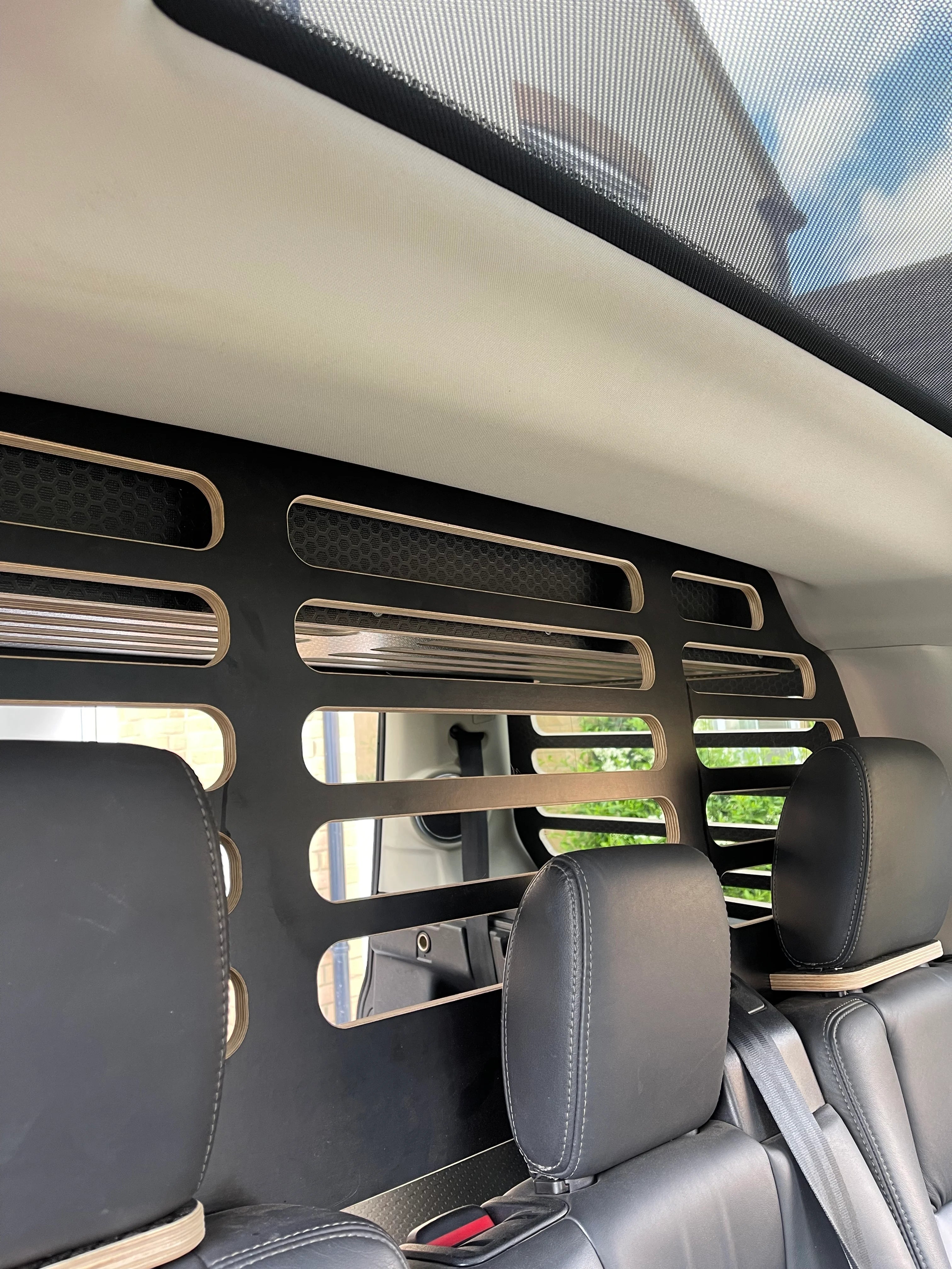 Car interior with a pet barrier installed between the mid row seats