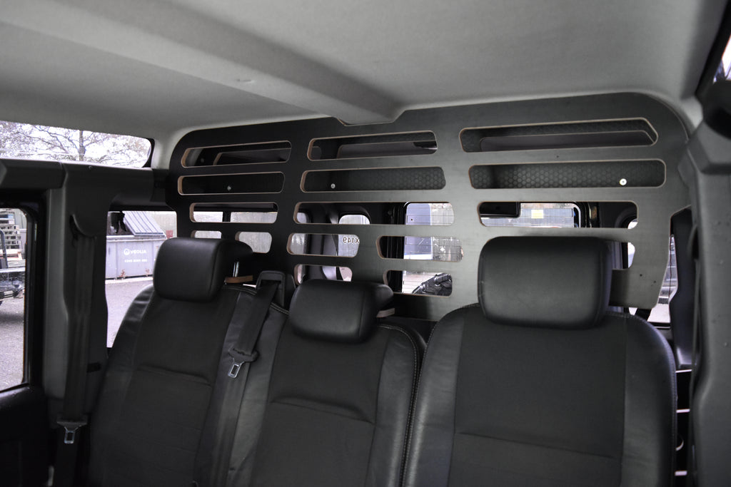 Van interior with black seats and a Dog Guard