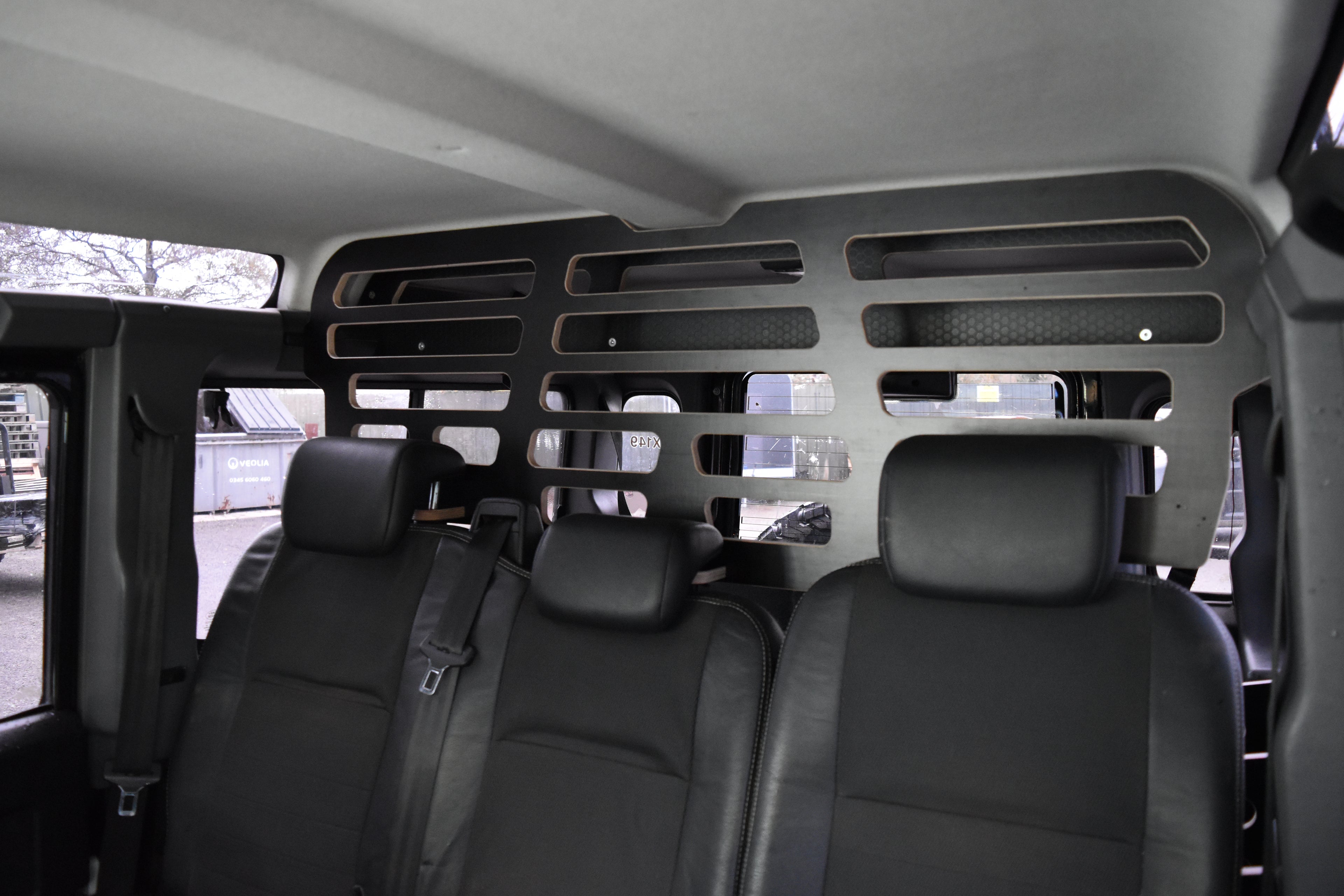 Van interior with black seats and a Dog Guard