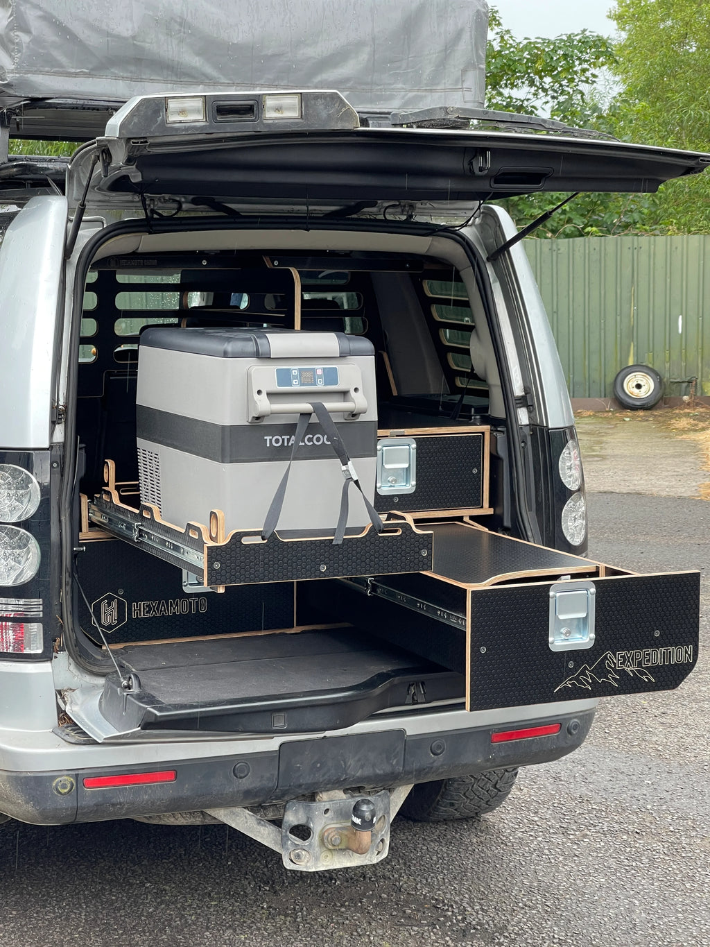 Land Rover Discovery 3 with open cargo area showing a Total Cool cooler and Hexamoto branded storage system