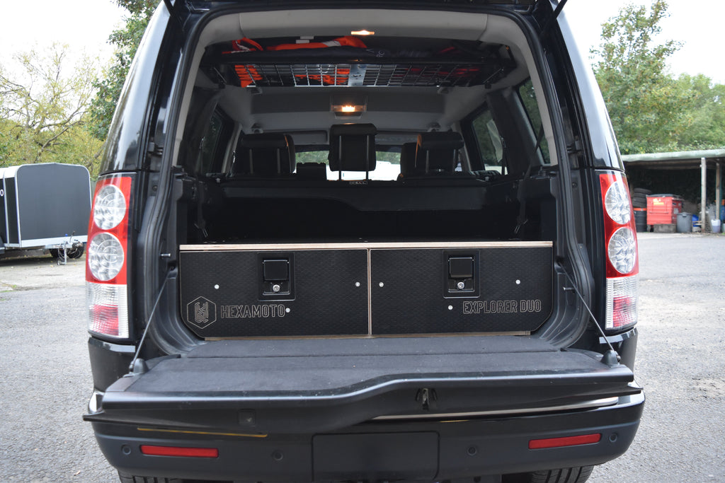 Back of a black SUV with open cargo area, showing 'Hexamoto Expedition' branded storage system