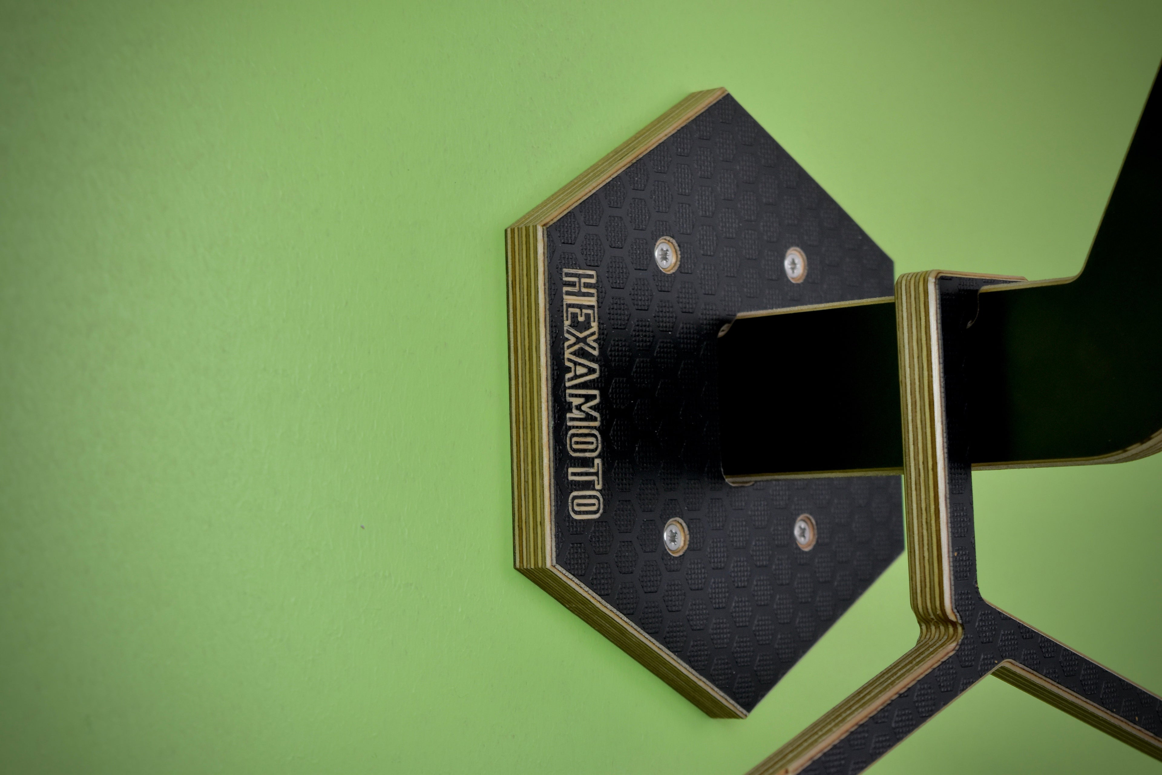 Hexamoto Mini back plate mounted to wall with a green background