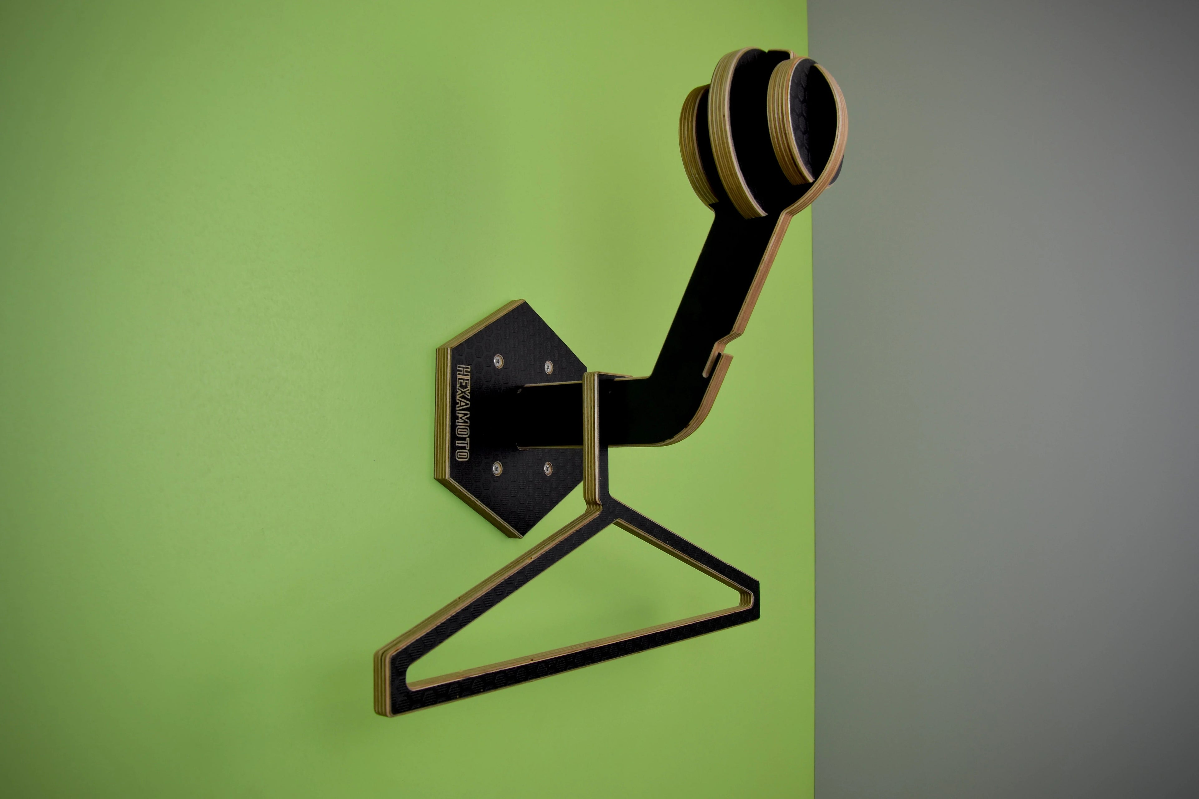 Hexamoto Mini mounted to wall featuring it's geometric design on a green and gray background