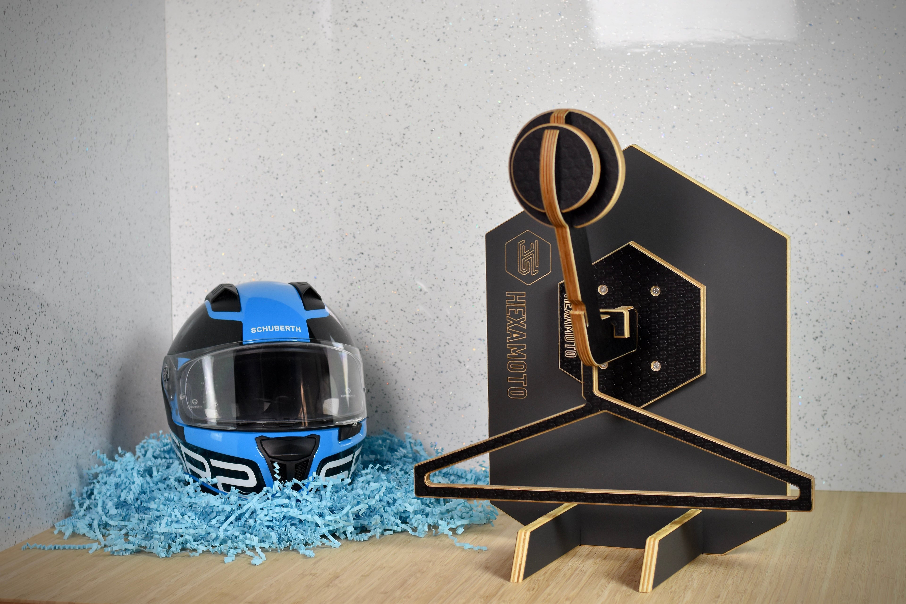 Motorcycle helmet on a Hexamoto Mini with decorative elements on a wooden surface.