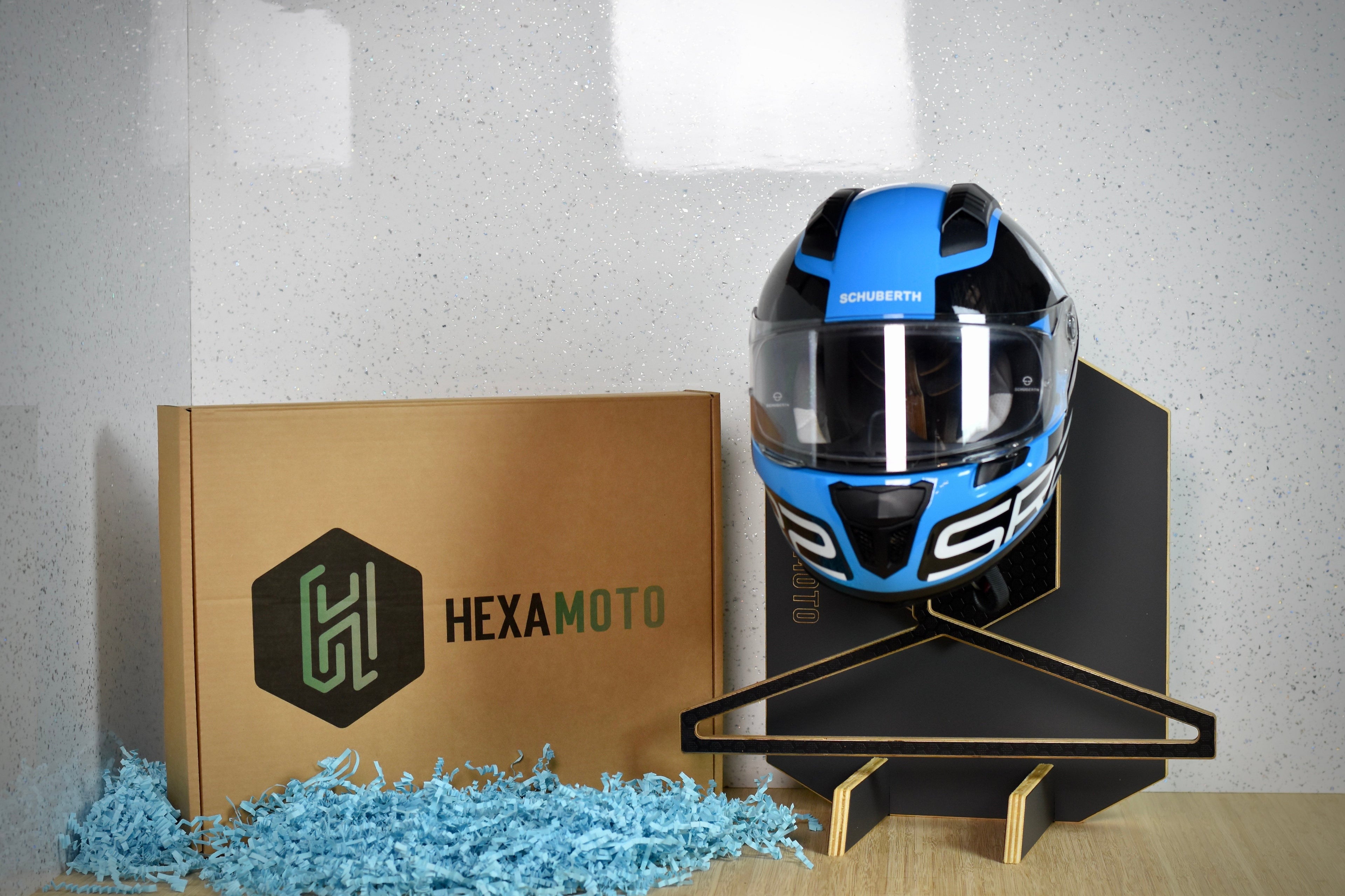 Blue and black motorcycle helmet on a stand next to a HEXAMOTO branded box.