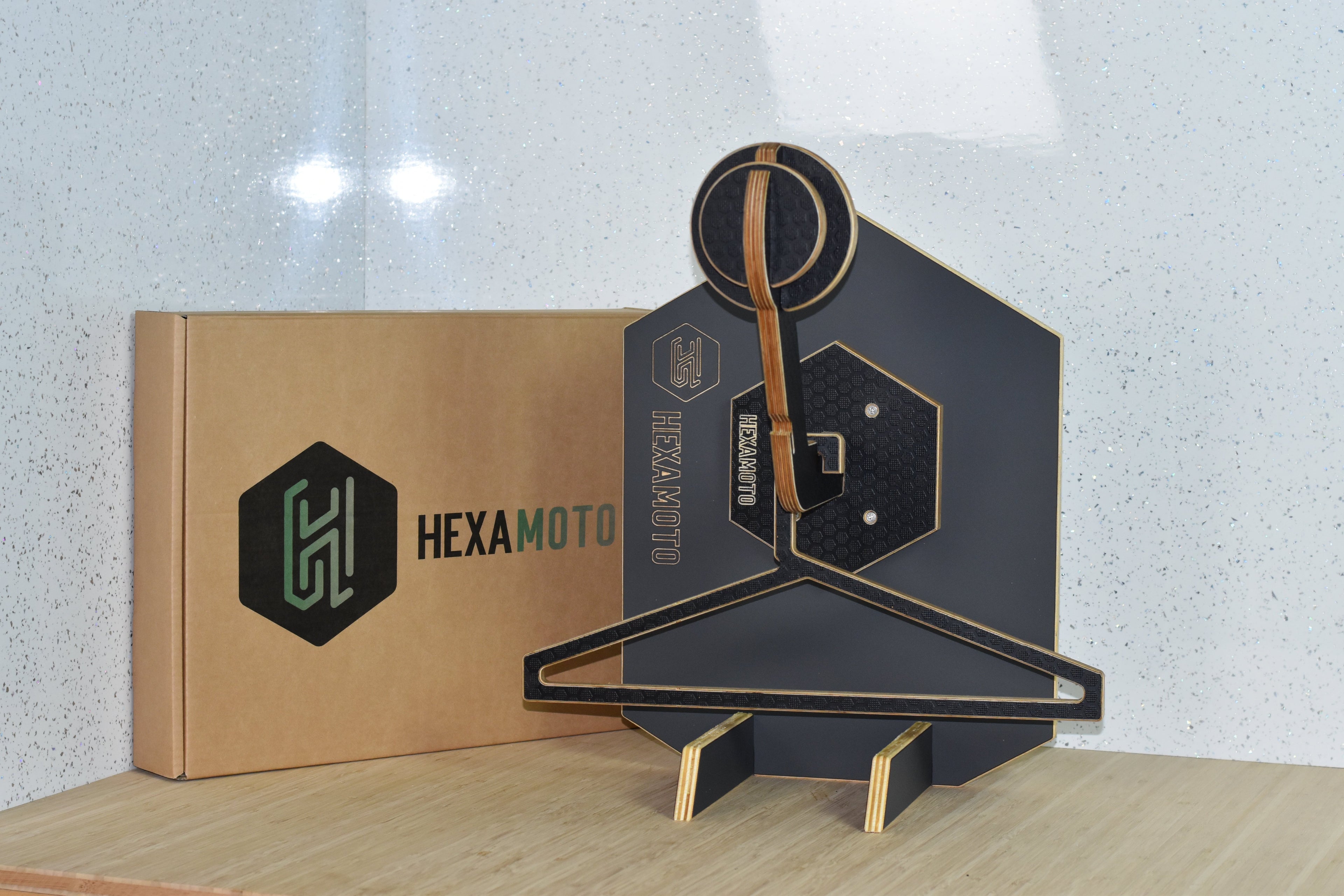 Hexamoto Mini helmet stand display with packaging on a light surface