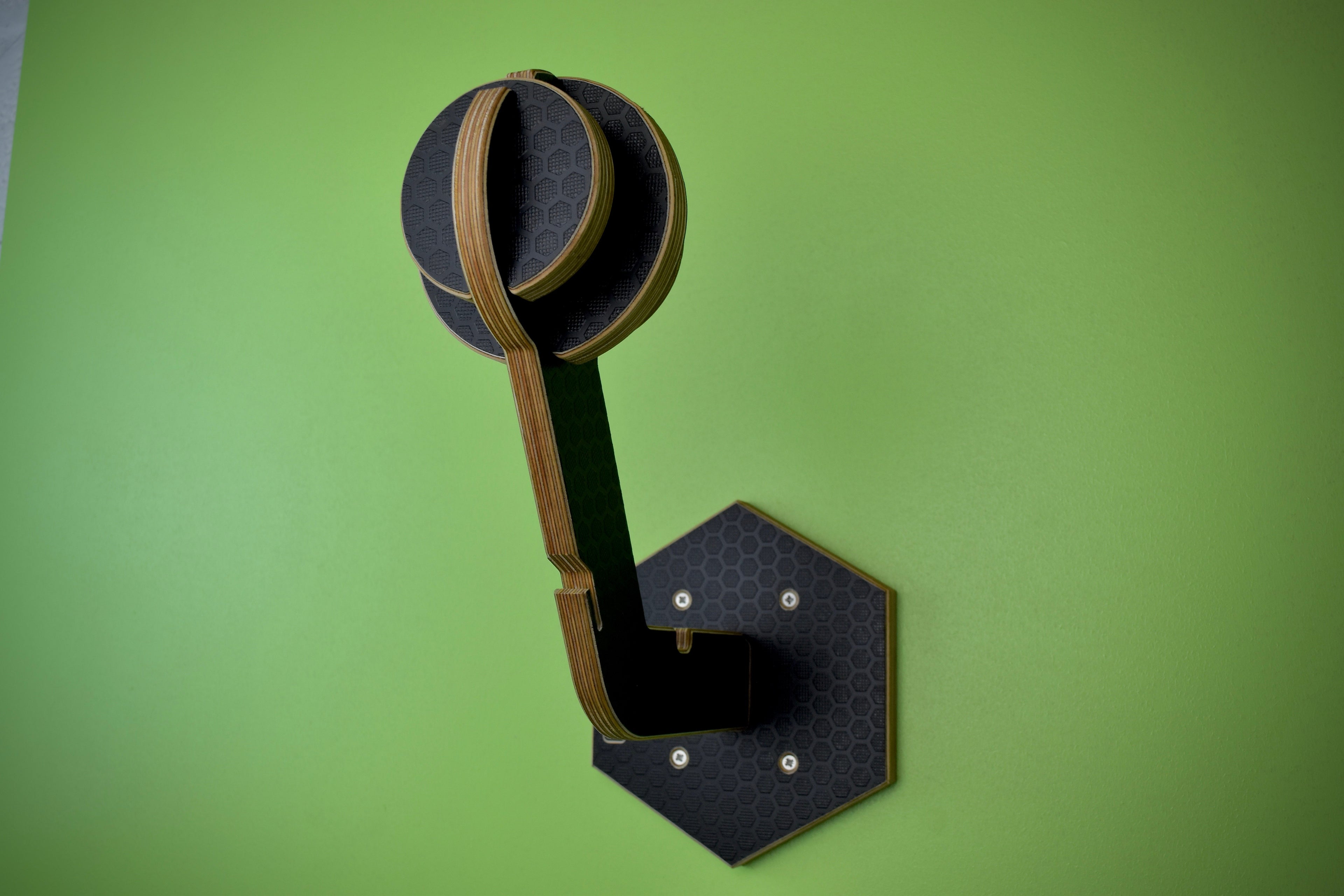 Wall hook for helmet and leather jacket, with a geometric design on a green background