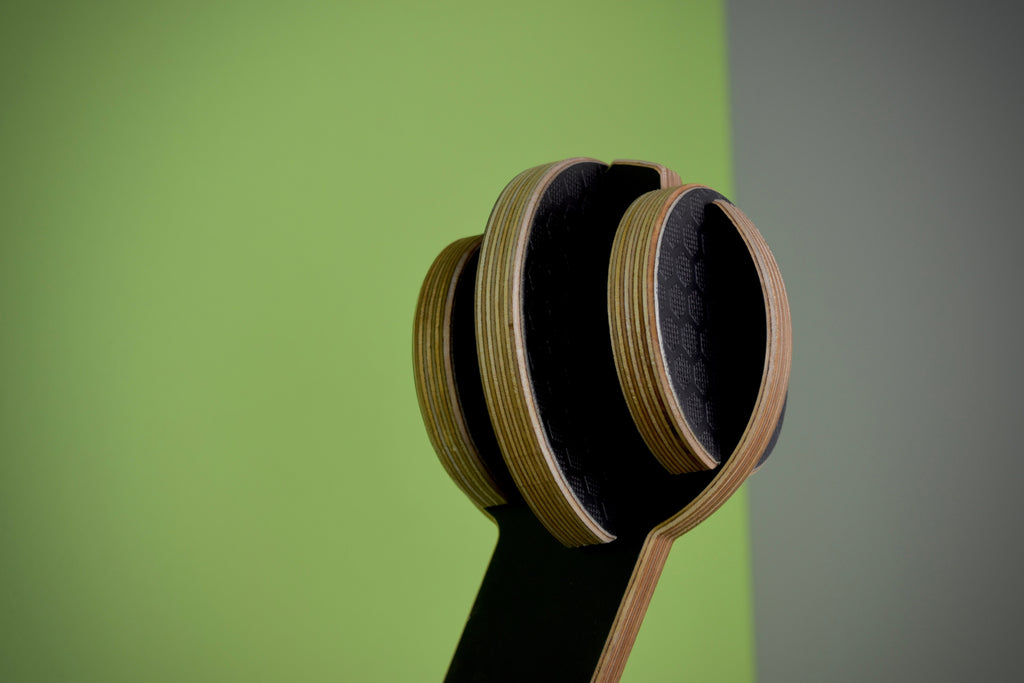 Wooden fixture used to mount motorcycle helmet on green and grey background