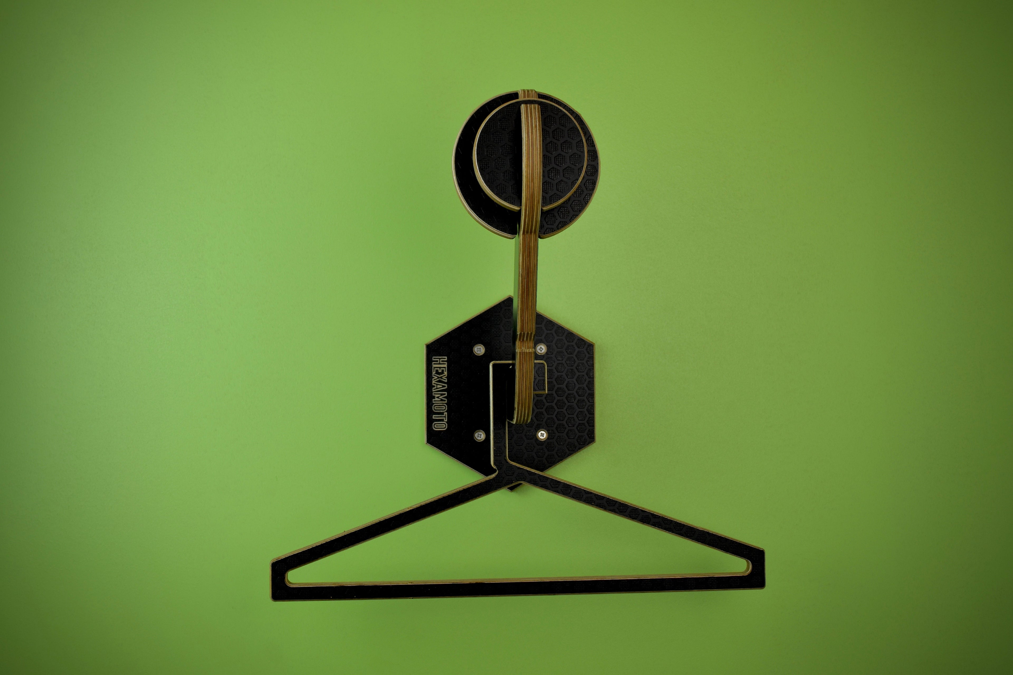 Helmet mount and clothing hanger on a green background