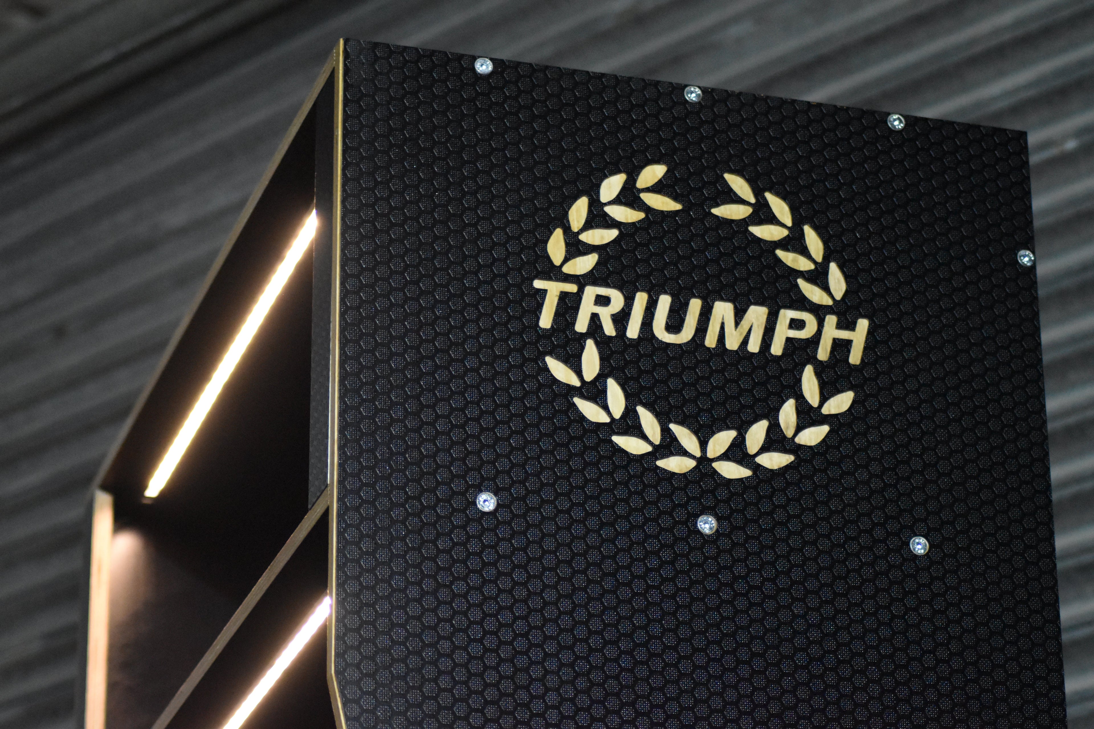 Triumph logo on a black textured background 