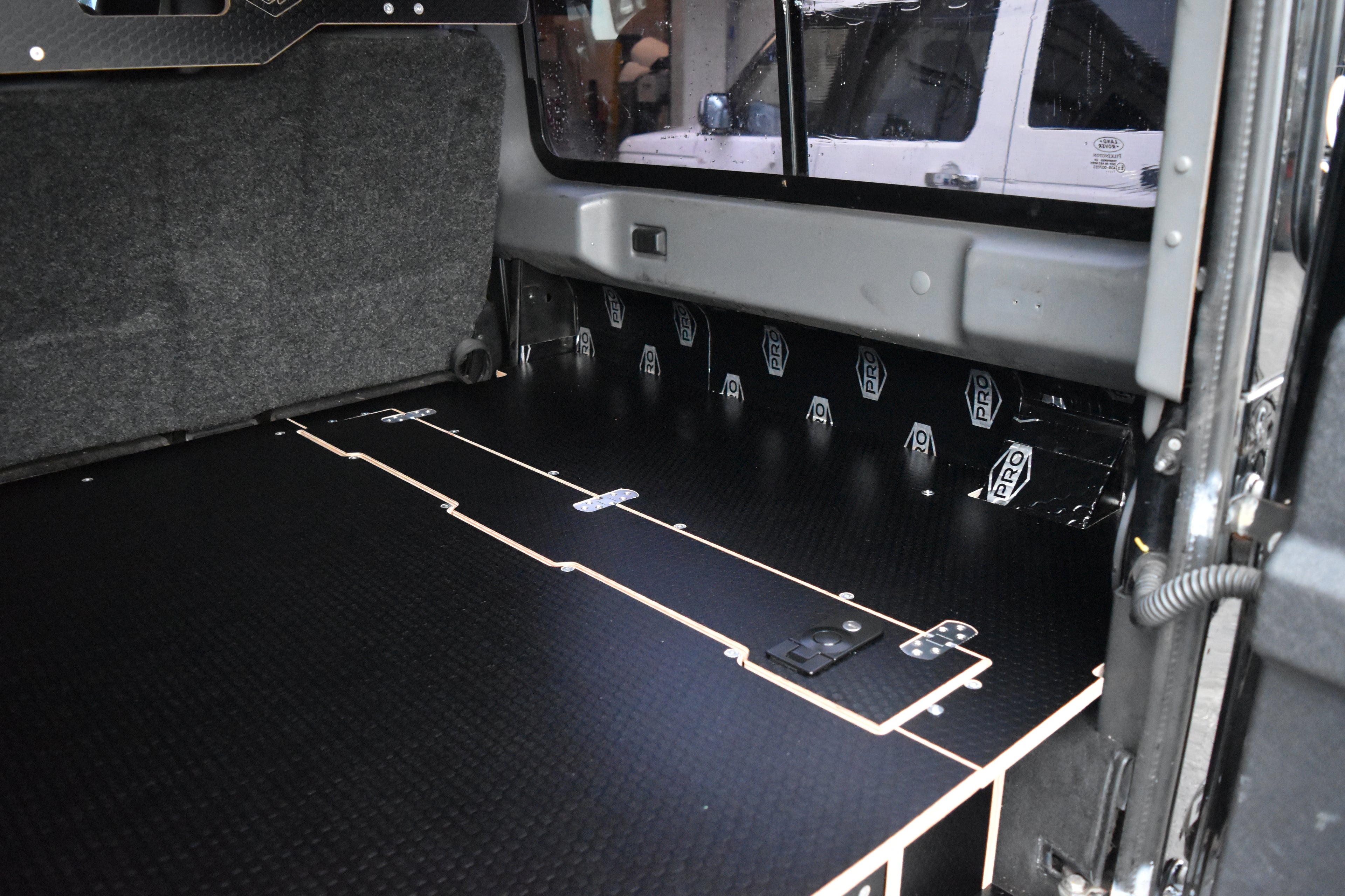 Black wooden storage system in Defender 110 with top cubby hole 