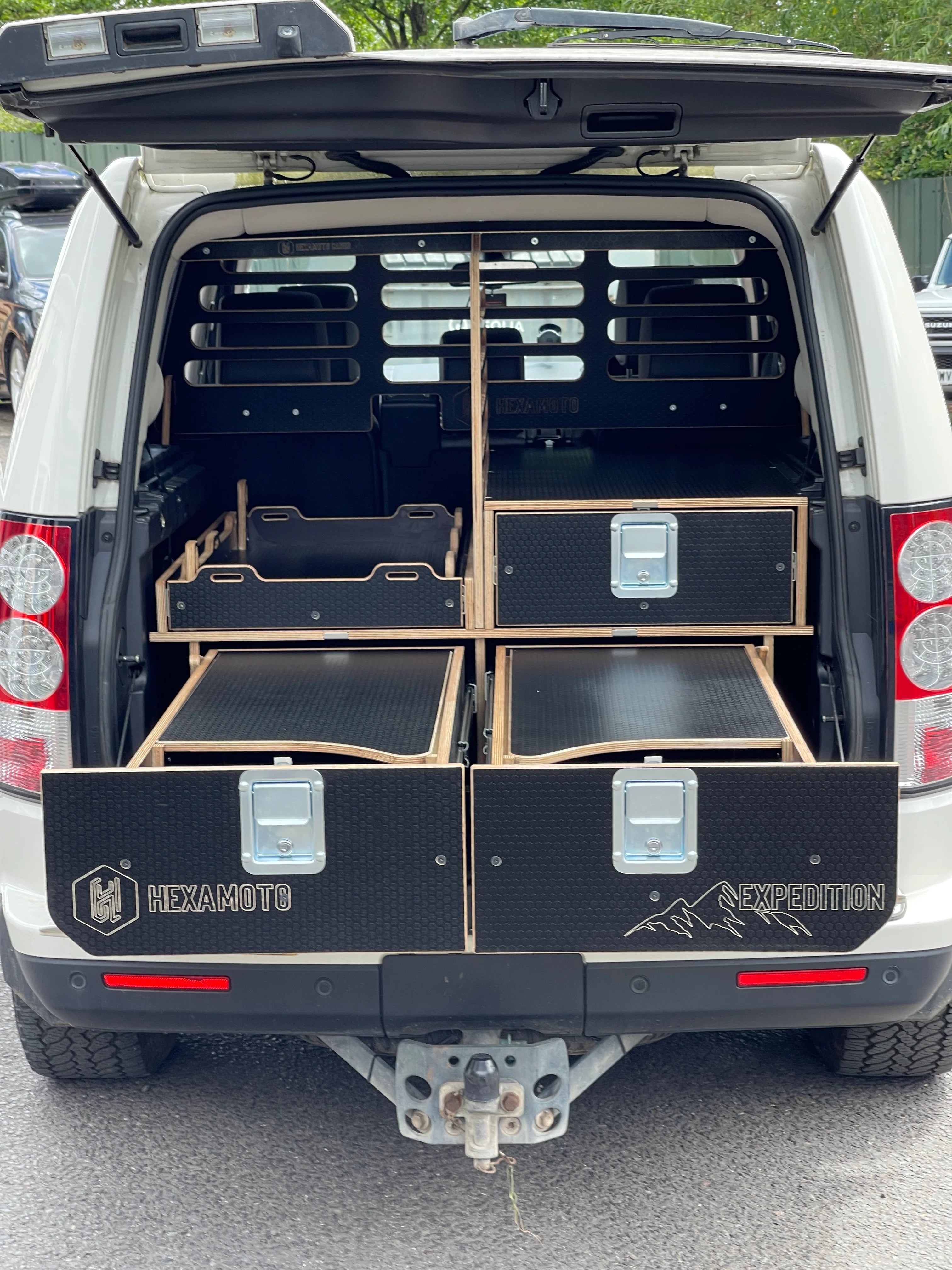Back of a vehicle with black storage drawers and HEXAMOTO branding.
