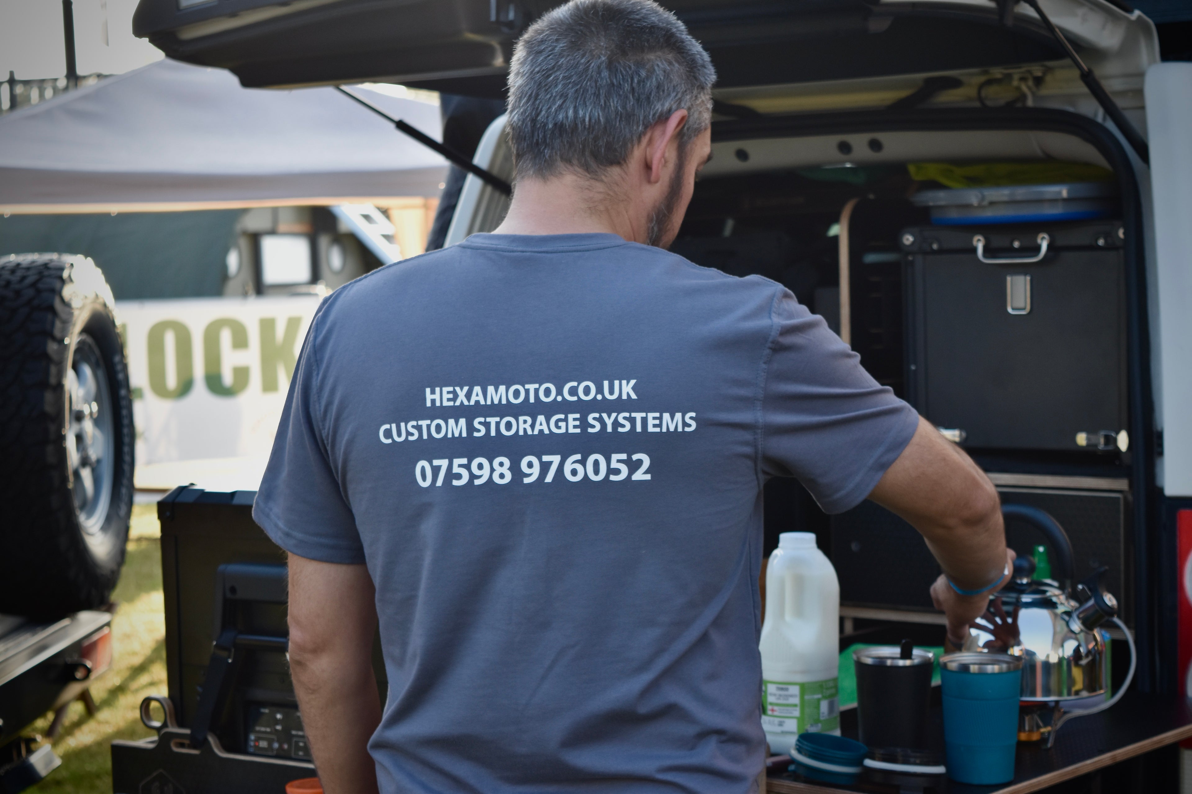 Man in a grey t-shirt with Hexamoto contact details, whilst making coffee on the Hexamoto Country system
